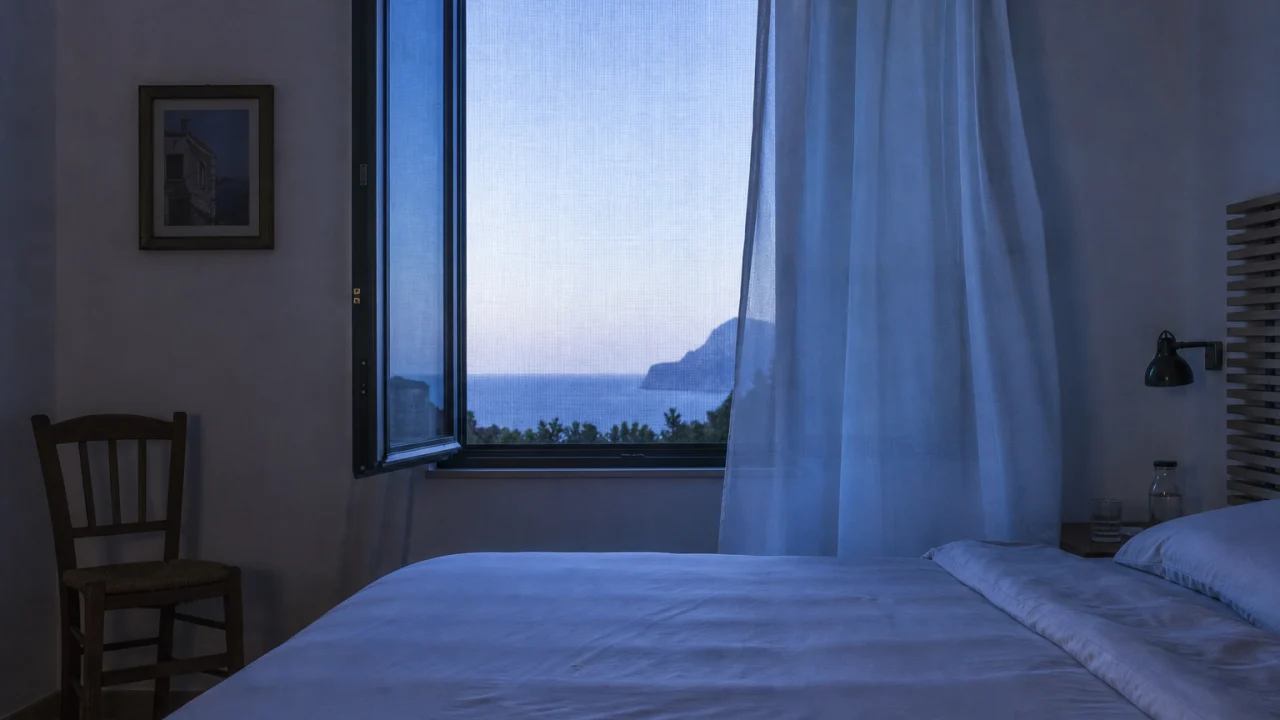 Camera da letto estiva con finestra aperta, tenda leggera è zanzariera visibile.